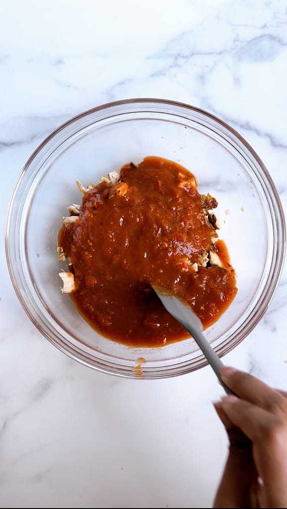 salsa poured over a bowl of grilled chicken