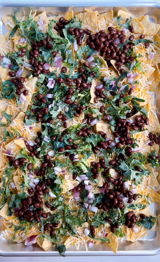 Black beans, kale and cheese on top of tortilla chips