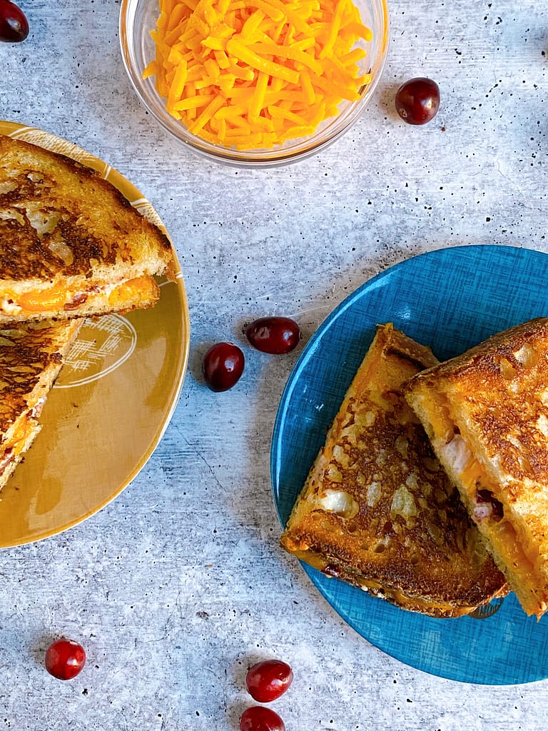 Sliced and plated Cranberry Goat Grilled Cheese with cranberries for garnish